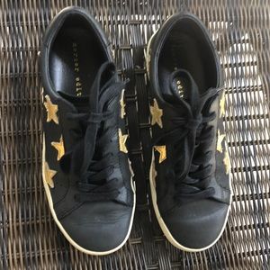 leather sneakers with gold stars sewn on them.